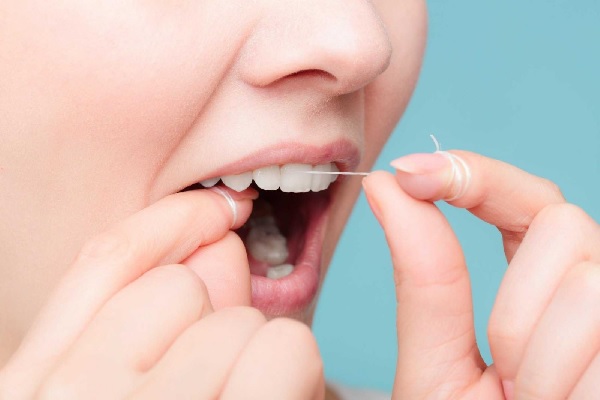 Sử dụng chỉ nha khoa để khiến răng lung lay