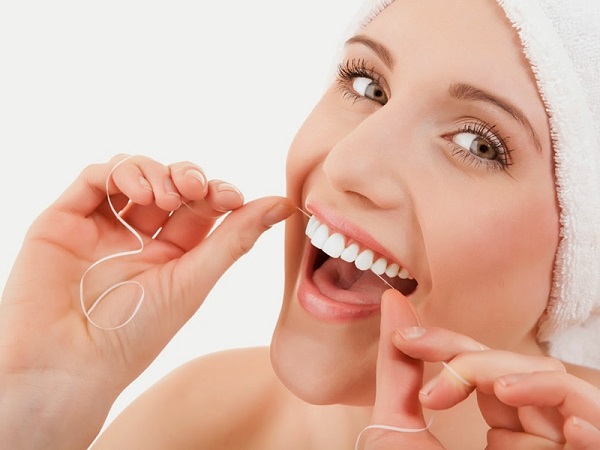 Sử dụng chỉ nha khoa để vệ sinh răng miệng.